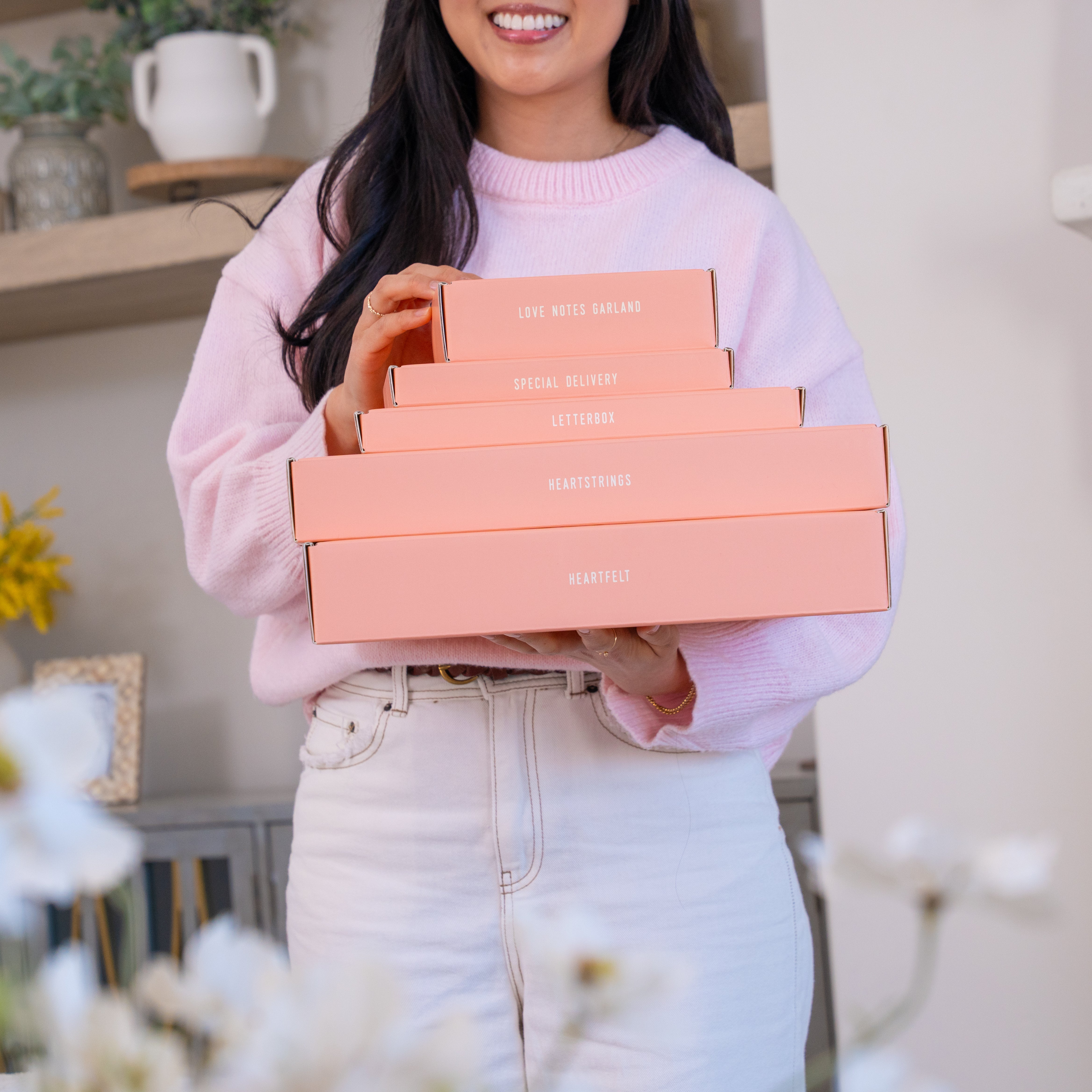 woman holding a stack of pink boxes from Crafted by C9's Valentine's collection of craft kits