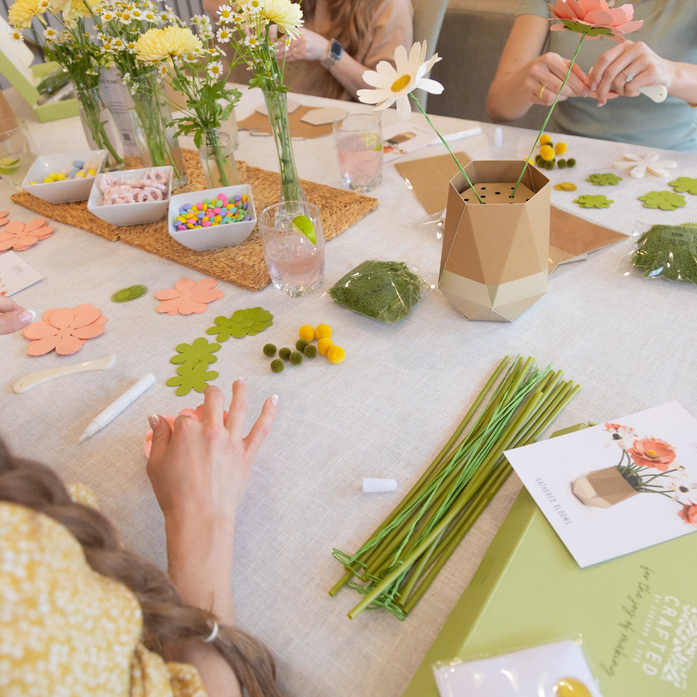 Adult women making paper flowers from craft kits during an afternoon