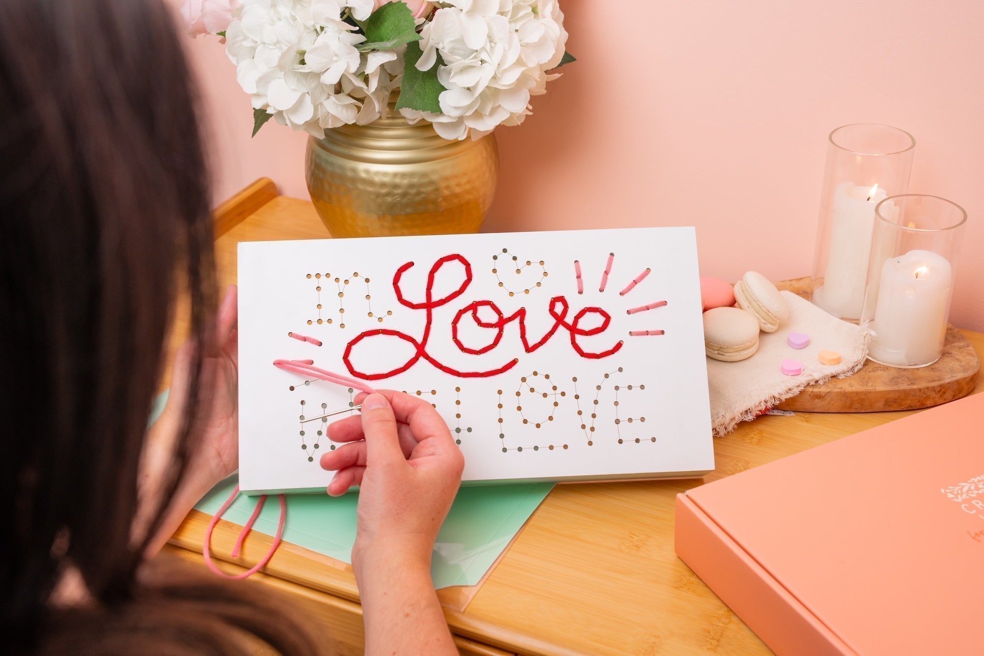 Teen girl making a string art craft DIY sign