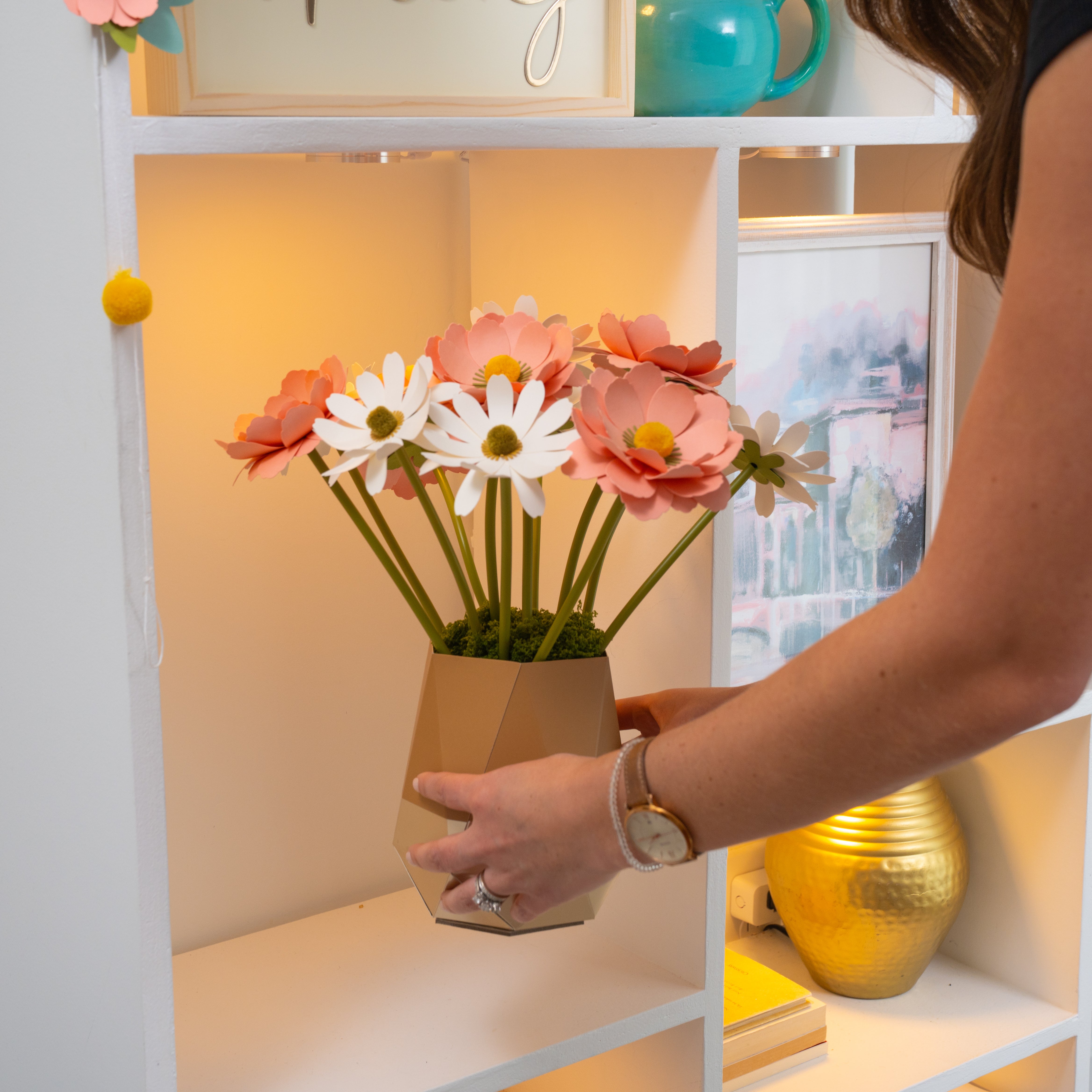 personal arranging DIY paper flowers in a vase to display in her home as decor