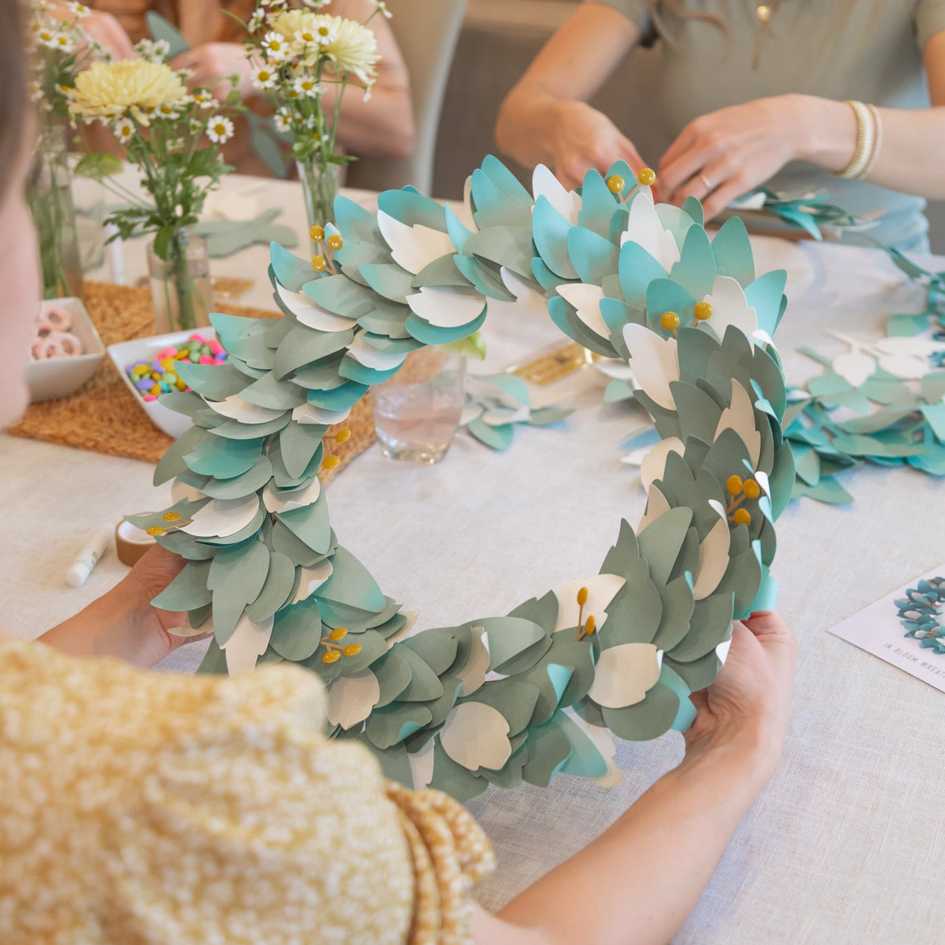 People making paper wreaths at a craft night for adult women