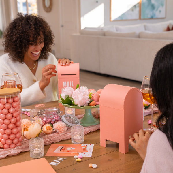 women creating a pink mailbox for valentine's day during a craft party