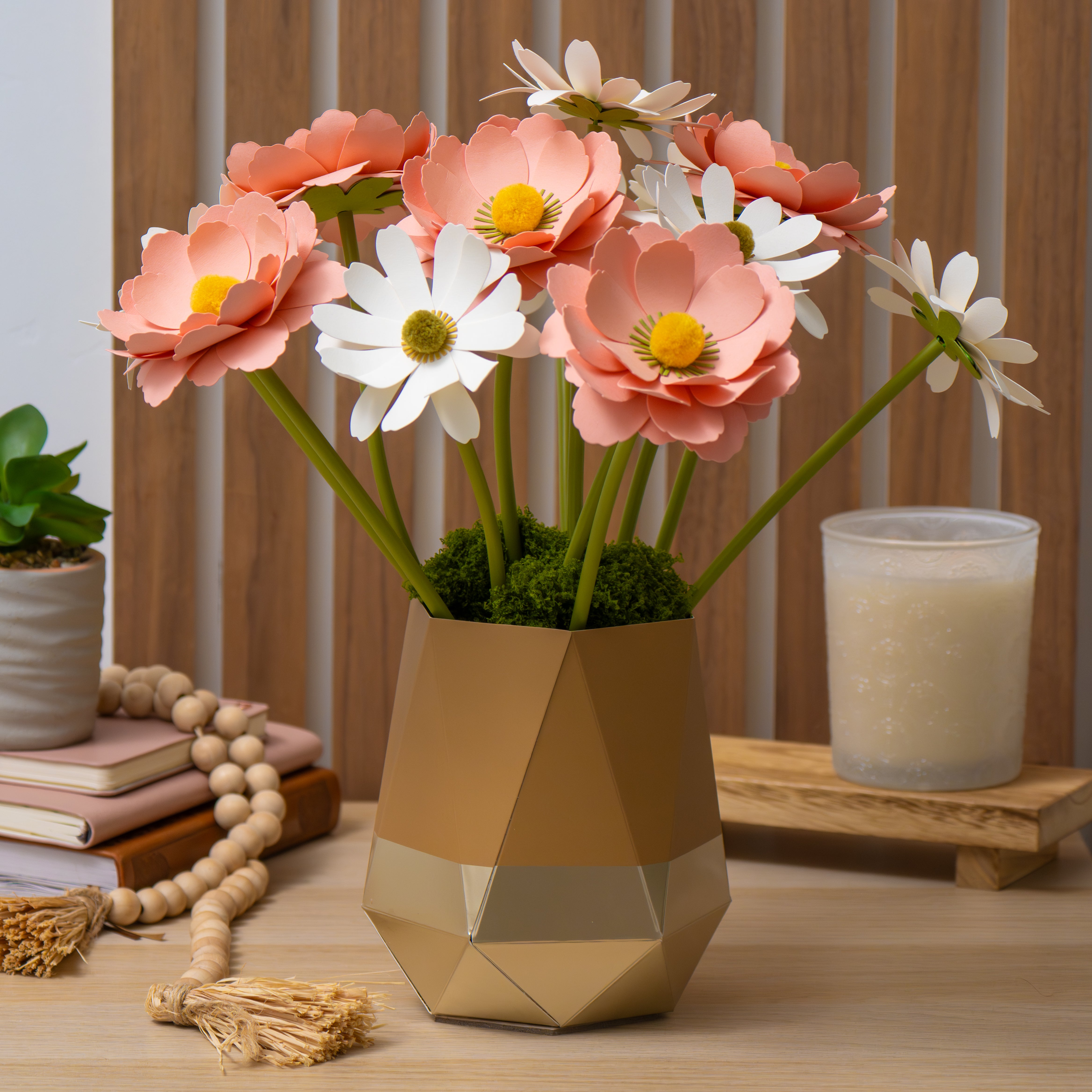 Geometric gold vase with pink and white paper flowers on a table
